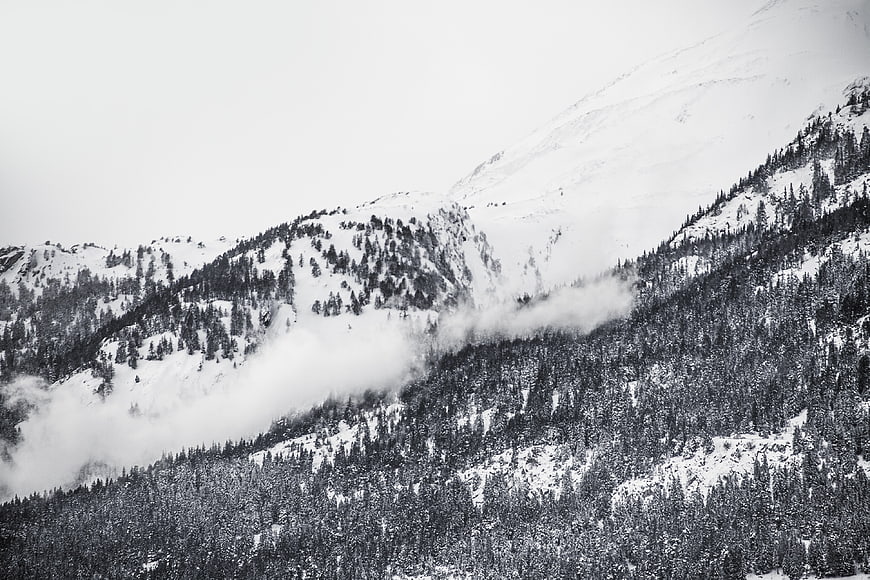 Black and white winter mountain landscape with snow and fog