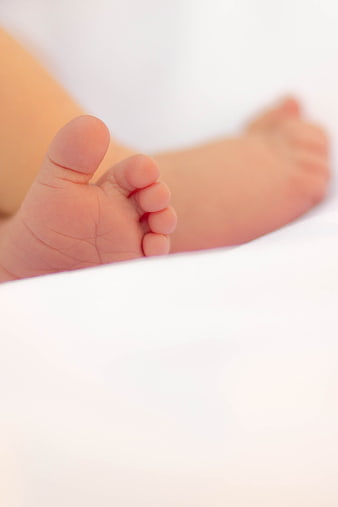 Close-up of newborn baby feet on white blanket