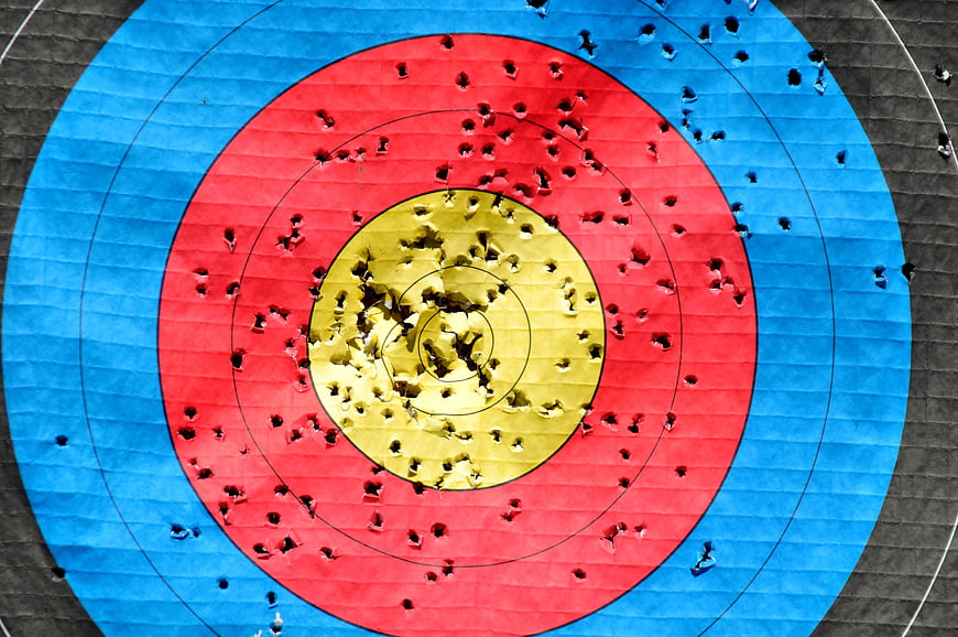 Close-up of colorful archery target with many arrow holes