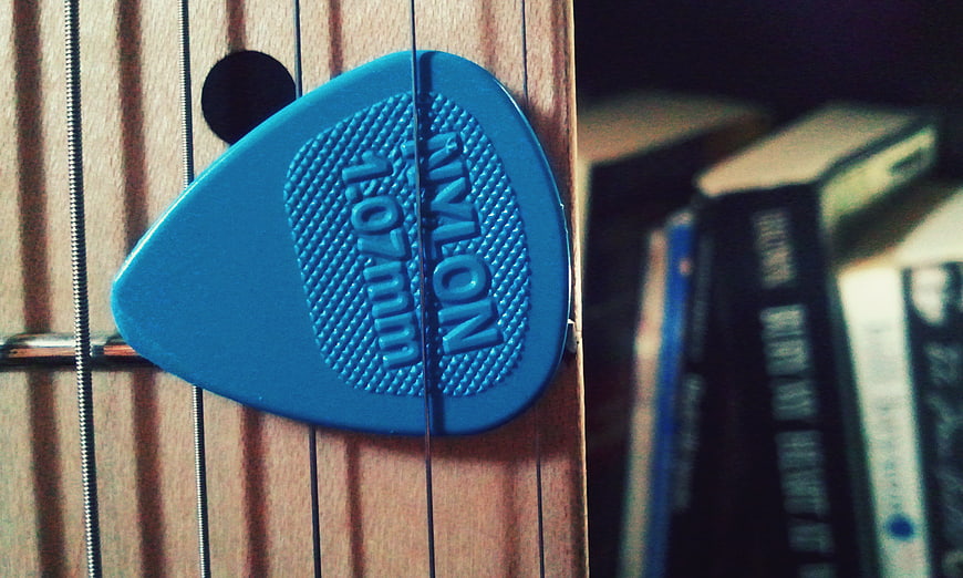 Blue Nylon Guitar Pick on Acoustic Guitar Strings