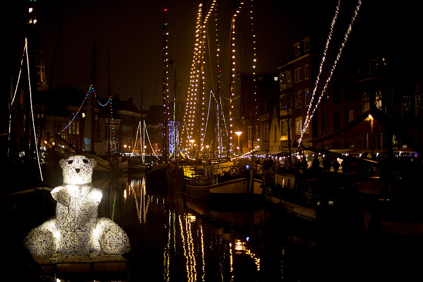 Illuminated Polar Bear Sculpture on Canal at Night
