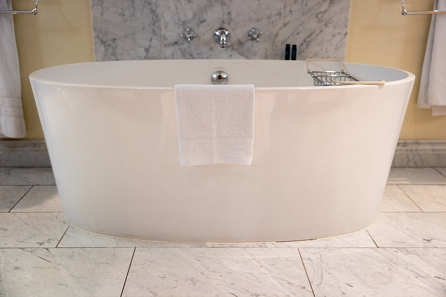 Modern White Freestanding Bathtub in Luxury Marble Bathroom