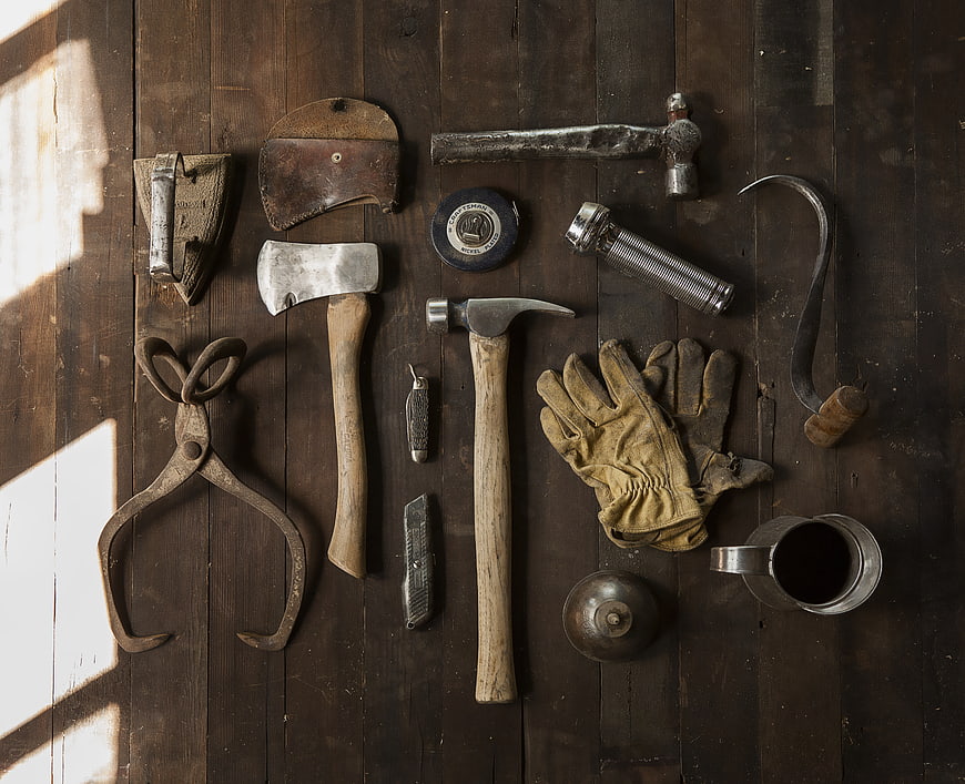 Vintage woodworking tools and leather gloves on rustic wood