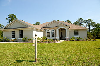 Single-story beige house for sale with green lawn