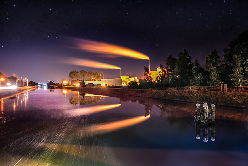 Industrial Factory with Glowing Steam Plumes at Night