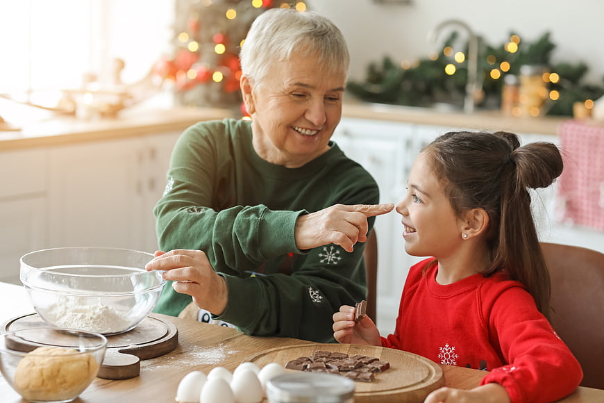 Grandmother and granddaughter baking cookies together in kitchen