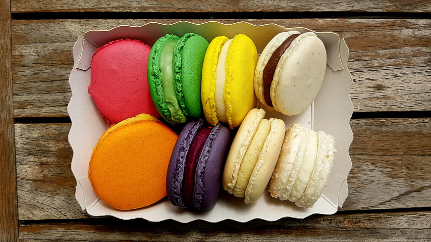 Colorful macarons in a box on a wooden table