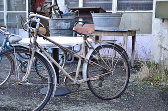 Rusty vintage bicycle in cluttered outdoor yard