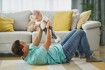 Happy Father Playing with Baby on Living Room Floor