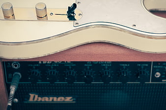 Close-up of white electric guitar resting on Ibanez amplifier