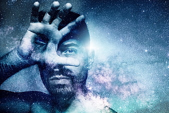Double exposure man with galaxy background looking through hand