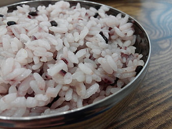 Close-up of cooked white and black rice in a metal bowl