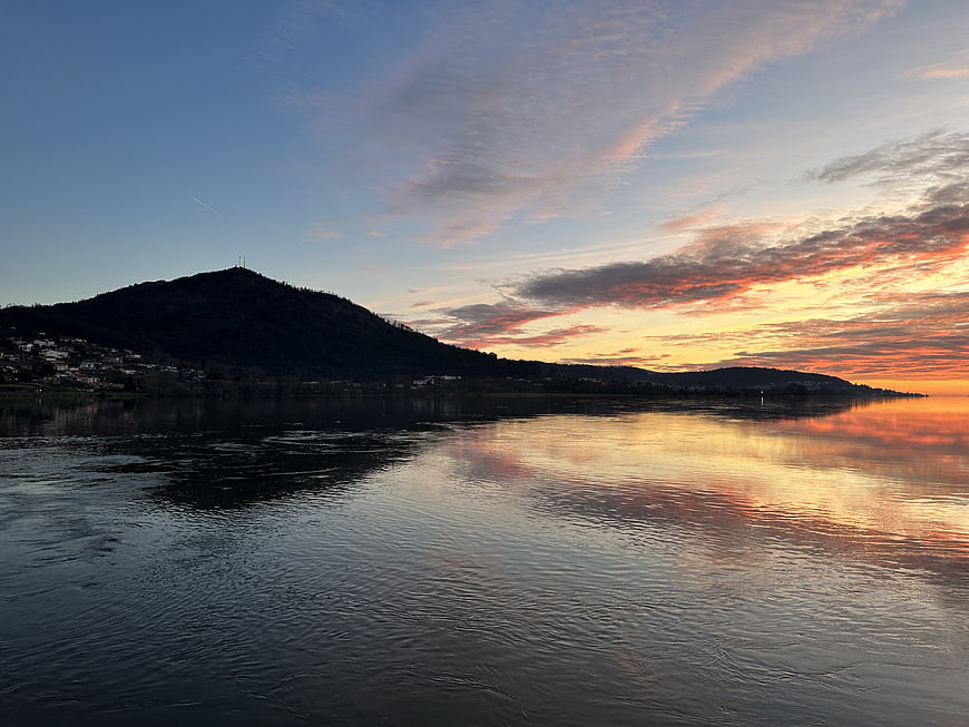 Serene Sunset Over Lake with Mountain Silhouette and Reflection