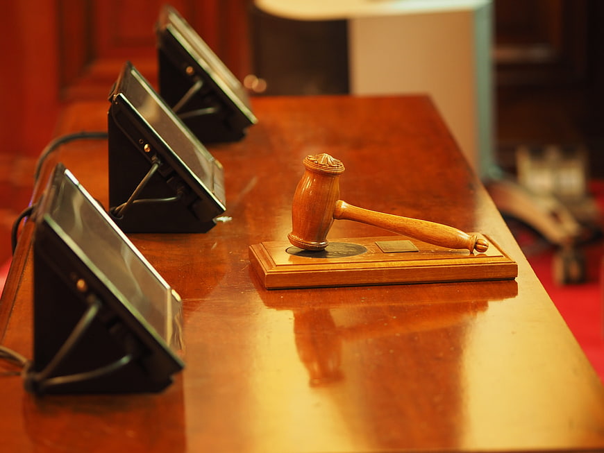 Wooden gavel and sound block on polished courtroom table