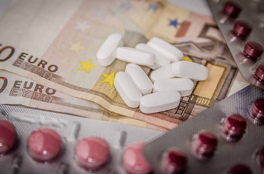 White pills and euro banknotes with blister packs