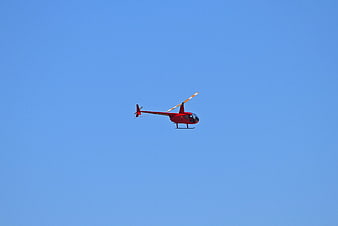 Red Helicopter Flying in Blue Sky