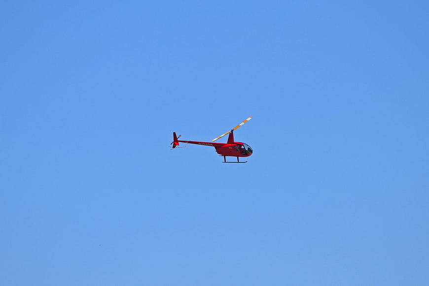 Red Helicopter Flying in Blue Sky
