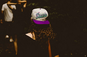 Woman Wearing White and Purple Baseball Cap at Night