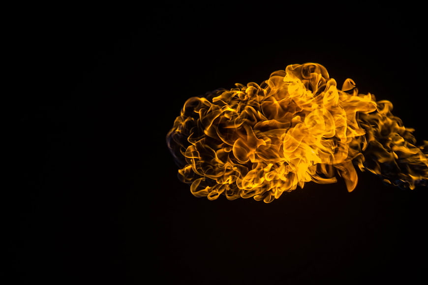 Vibrant yellow flame burst isolated on black background