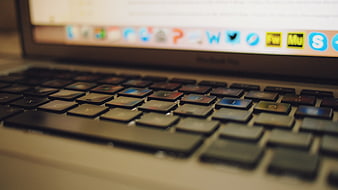 Close-up of MacBook Keyboard with Blurred Screen