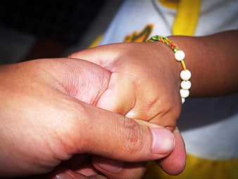 Close-up of elderly hand holding child's hand with bracelet