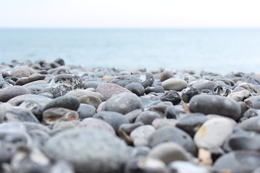 Close-up of smooth pebbles on a calm beach shoreline