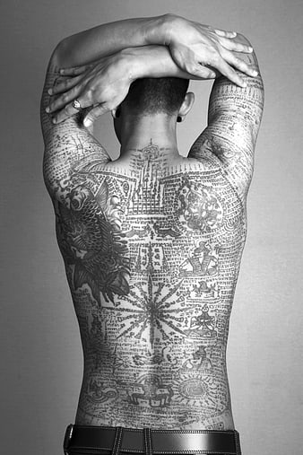 Man with intricate Thai traditional back tattoo in black and white