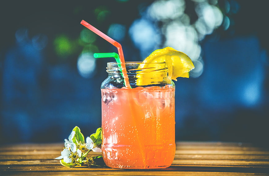 Refreshing Pink Cocktail in Mason Jar with Lemon and Straw