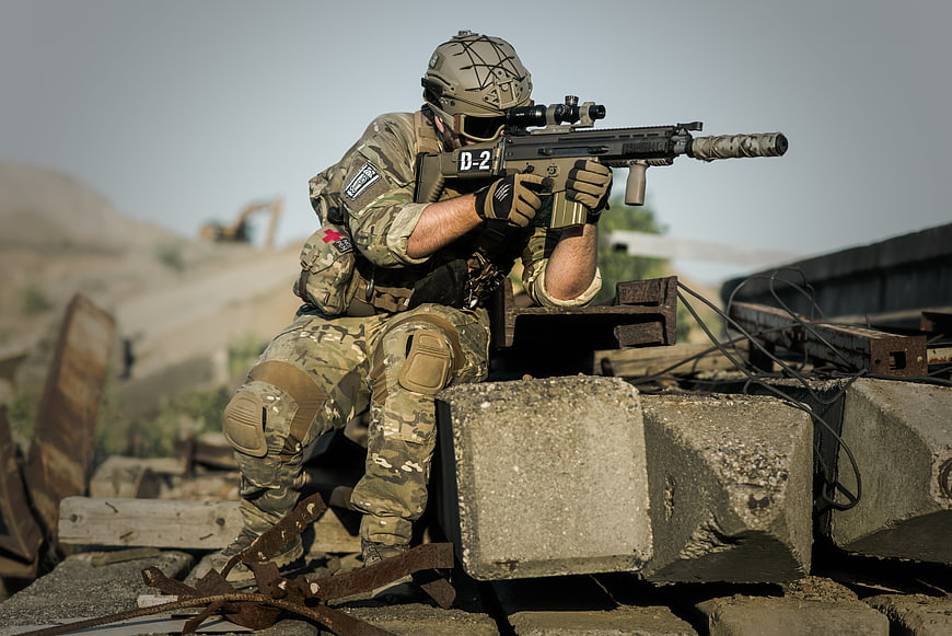 Soldier in Tactical Gear Aiming Rifle in Desert Ruins
