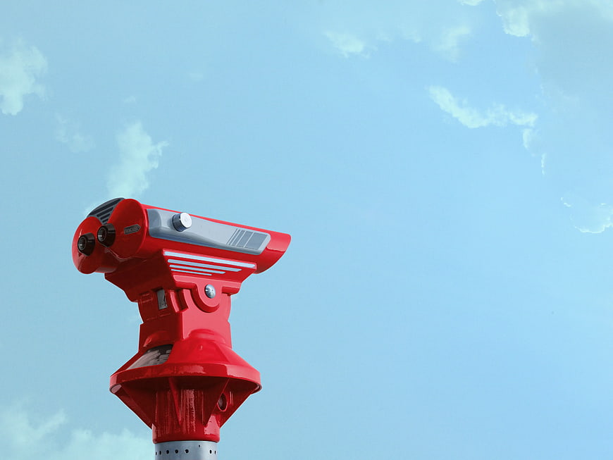 Red Surveying Theodolite Against Blue Sky