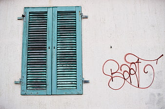 Vintage Teal Wooden Shutters on White Wall with Graffiti