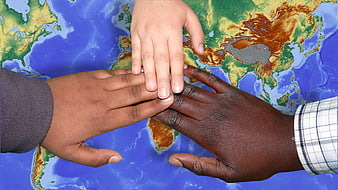 Diverse Hands Stacked on World Map Symbolizing Unity