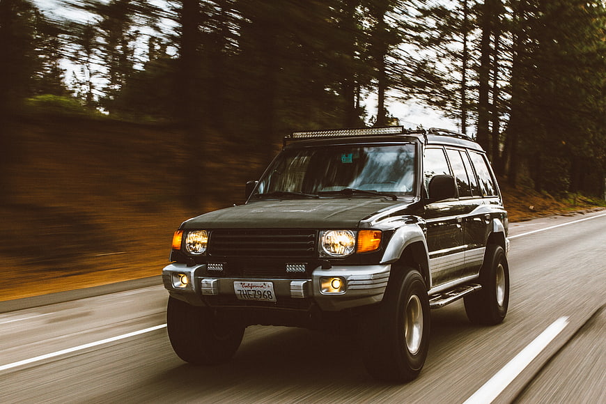 Black SUV Driving Fast on Forest Road