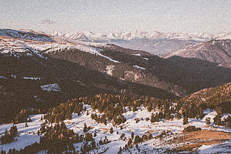 Snowy Mountain Landscape with Pine Forests and Distant Peaks