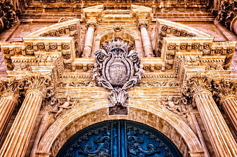 Ornate Baroque Church Facade with Blue Door and Stone Carvings