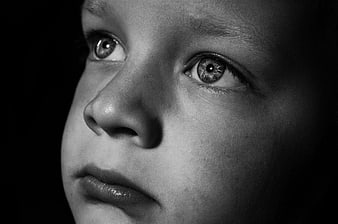 Close-up black and white portrait of a child's face looking up