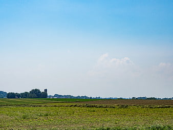 Wide Rural Farmland with Green Fields and Blue Sky