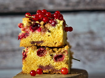 Stacked yeast cake with red currants on wooden board