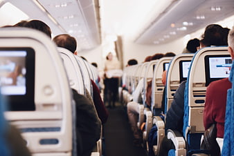 Passengers seated in airplane cabin aisle view