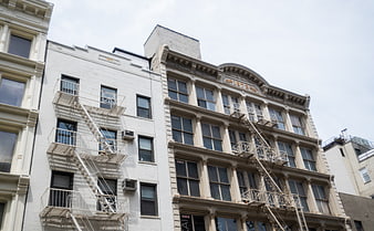 Low angle view of historic urban building facades with fire escapes