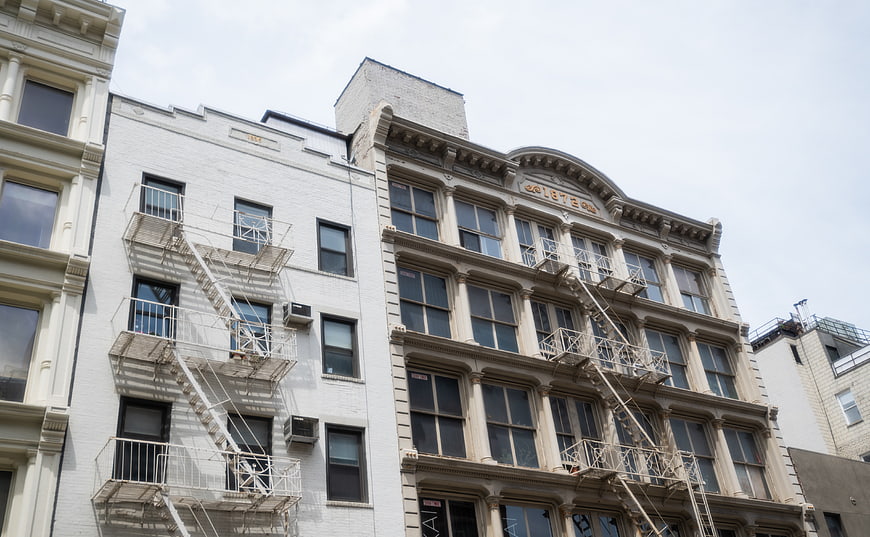 Low angle view of historic urban building facades with fire escapes