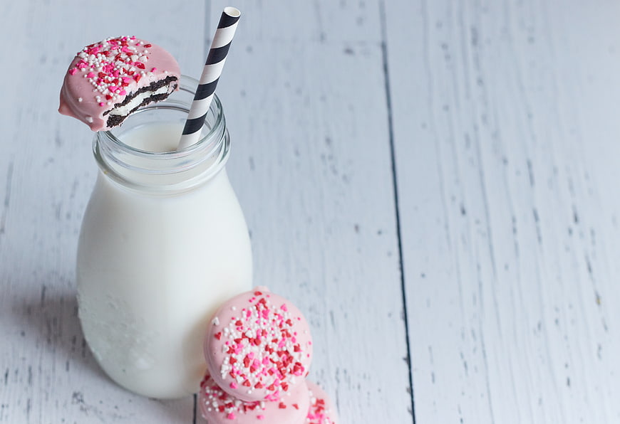 Pink Chocolate Cookies with Milk Bottle on White Wood