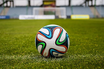 Soccer ball on green grass field in stadium