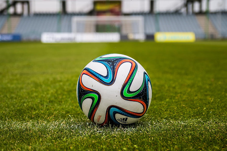 Soccer ball on green grass field in stadium
