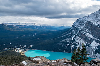Turquoise Lake in Snowy Mountain Valley with Cloudy Sky