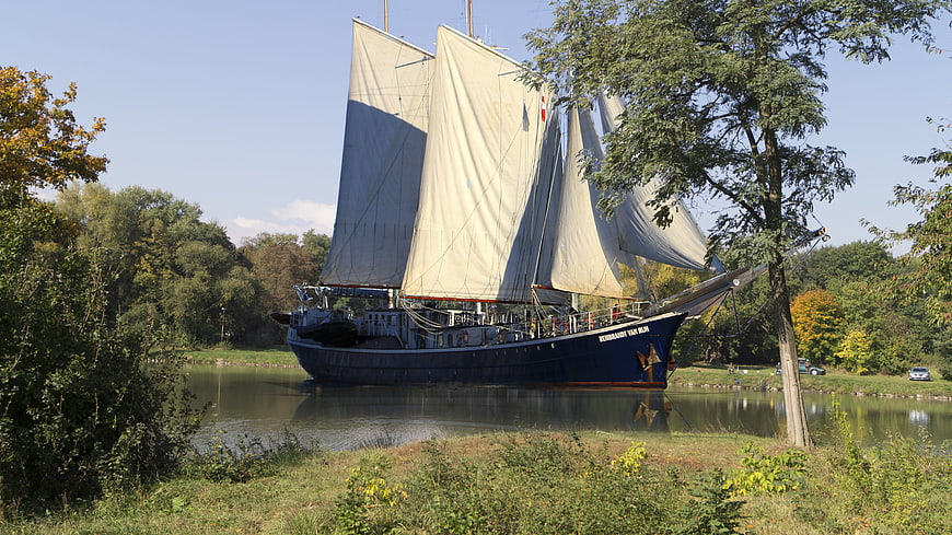 Traditional Blue Sailboat on River in Autumn