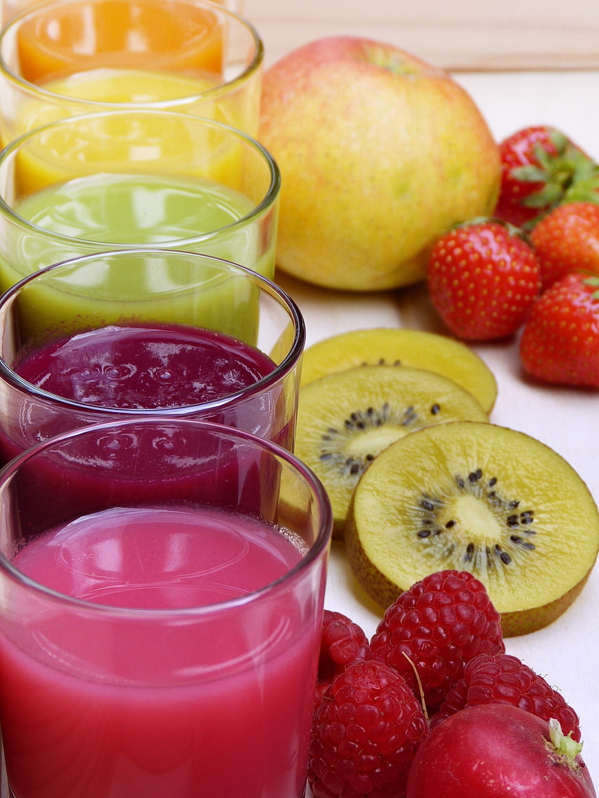 Colorful Fruit Juices in Glasses with Fresh Apples, Strawberries, Kiwi, and Raspberries