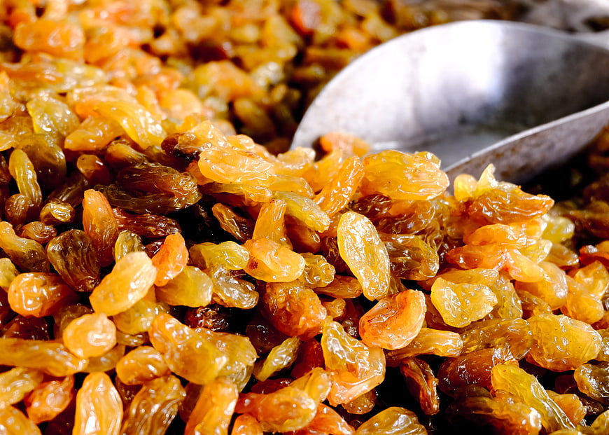 Close-up of golden raisins with metal scoop