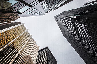Low angle view of modern skyscrapers against cloudy sky
