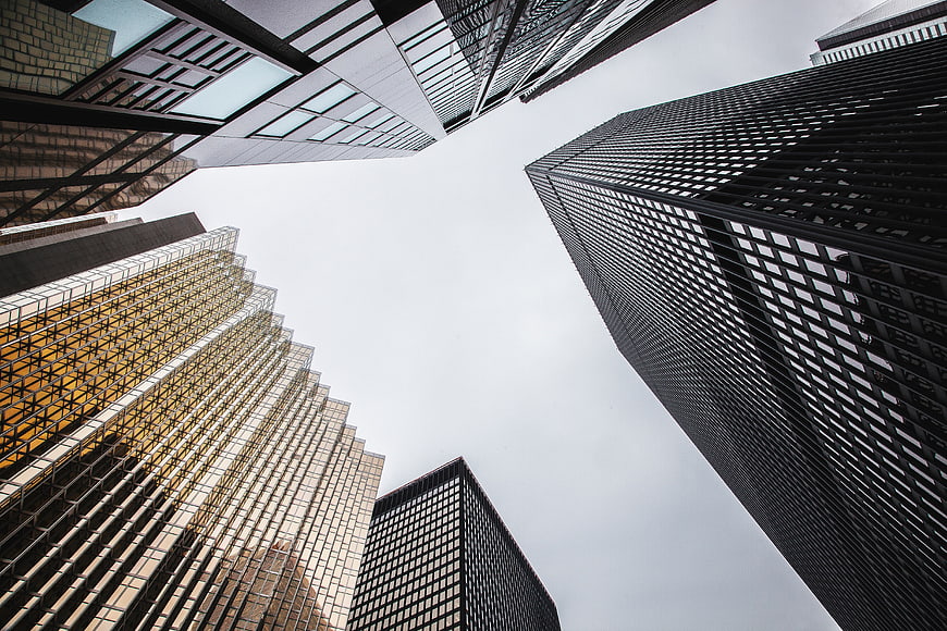 Low angle view of modern skyscrapers against cloudy sky